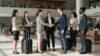 Personnes d'affaires internationales se serrant la main dans un aéroport.